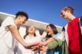 Happy young friends stacking hands. Diverse group of people celebrating and having fun together. Royalty Free Stock Photo