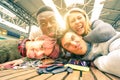 Happy young friends taking selfie indoors with back lighting