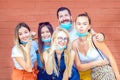 Happy young friends taking selfie with open face masks making funny faces