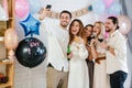 Happy young friends taking selfie together during gender reveal party