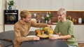 Happy young gay couple sitting at table in kitchen Royalty Free Stock Photo