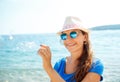 Happy young girl blowing soap bubbles on the seashore Royalty Free Stock Photo