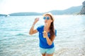 Happy young girl blowing soap bubbles on the seashore Royalty Free Stock Photo