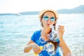 Happy young girl blowing soap bubbles on the seashore Royalty Free Stock Photo