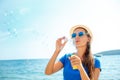 Happy young girl blowing soap bubbles on the seashore Royalty Free Stock Photo