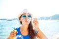 Happy young girl blowing soap bubbles on the seashore Royalty Free Stock Photo