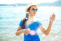 Happy young girl blowing soap bubbles on the seashore Royalty Free Stock Photo