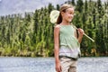 Happy young girl with butterfly net standing by lake Royalty Free Stock Photo