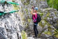 Happy young girl crossing a via ferrata wire bridge in Baia de Fier, Romania. Indian bridge on a klettersteig.