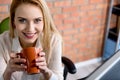 Happy young girl drinking her beverage against brick wall Royalty Free Stock Photo