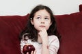 pretty young girl eating an apple on the couch in the livingroom