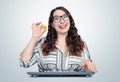Happy young girl in glasses behind the keyboard holds in her hand bitcoin. earn digital money concept