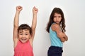 Happy young girl with hands up and her jealous older sister