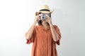 Happy young girl in hat takes photo with old camera in studio Royalty Free Stock Photo