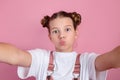 Happy young girl having fun and taking a selfie over pink background Royalty Free Stock Photo