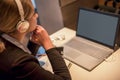 Happy young girl with headphones looking at laptop screen, reading listening online courses, studying or working remotely Royalty Free Stock Photo