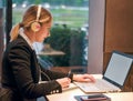 Happy young girl with headphones looking at laptop screen and smiling, reading listening online courses, studying or working Royalty Free Stock Photo