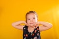 Happy young girl with her hands clasped together beneath her chin, smiling joyfully Royalty Free Stock Photo