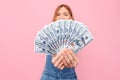 Happy young girl holding cash dollar bills on an isolated pink background Royalty Free Stock Photo