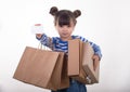 Happy young girl holding discount white card and shopping bags in her hands. Kid with credit card. Royalty Free Stock Photo