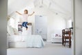 Happy young girl jumping on bed in her bedroom Royalty Free Stock Photo