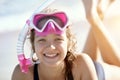 Happy young girl lies on the beach in fins and masks for scuba diving. Royalty Free Stock Photo