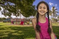 A happy young girl in pigtails smiles at the playground park