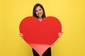 Happy young girl in pink suit holding big red heart Royalty Free Stock Photo