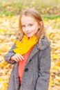 Happy young girl playing with falling yellow leaves in beautiful autumn park on nature walks outdoors. Little child Royalty Free Stock Photo