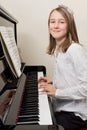 Happy young girl playing the piano