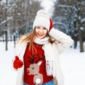 Happy young girl in a red sweater with a deer winks and smiling Royalty Free Stock Photo