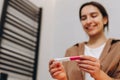 A happy young girl saw the coveted two stripes on the pregnancy test. Happy pregnant woman Royalty Free Stock Photo