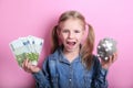 Happy young girl with silver piggy bank and euro banknotes  on pink background. save money concept. Royalty Free Stock Photo