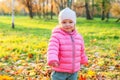 Happy young girl smiling in beautiful autumn park on nature walks outdoors. Little child playing in autumn fall orange Royalty Free Stock Photo