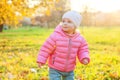 Happy young girl smiling in beautiful autumn park on nature walks outdoors. Little child playing in autumn fall orange yellow Royalty Free Stock Photo