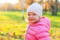 Happy young girl smiling in beautiful autumn park on nature walks outdoors. Little child playing in autumn fall orange yellow Royalty Free Stock Photo
