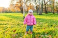 Happy young girl smiling in beautiful autumn park on nature walks outdoors. Little child playing with falling yellow maple leaf in Royalty Free Stock Photo