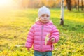 Happy young girl smiling in beautiful autumn park on nature walks outdoors. Little child playing with falling yellow maple leaf in Royalty Free Stock Photo