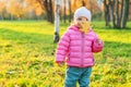 Happy young girl smiling in beautiful autumn park on nature walks outdoors. Little child playing with falling yellow Royalty Free Stock Photo