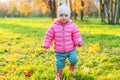 Happy young girl smiling in beautiful autumn park on nature walks outdoors. Little child playing with falling yellow Royalty Free Stock Photo