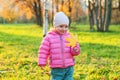 Happy young girl smiling in beautiful autumn park on nature walks outdoors. Little child playing with falling yellow Royalty Free Stock Photo