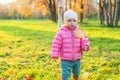 Happy young girl smiling in beautiful autumn park on nature walks outdoors. Little child playing with falling yellow Royalty Free Stock Photo