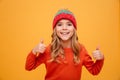 Happy Young girl in sweater and hat showing thumbs up Royalty Free Stock Photo