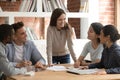 Happy young girl team leader having fun with diverse mates. Royalty Free Stock Photo