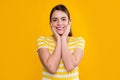 happy young girl touch face in summer striped tshirt on yellow background