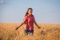 Young girl walking on field with ripe wheat Royalty Free Stock Photo