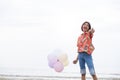 Happy young girl wear yellow shirt and hold balloon at beach Royalty Free Stock Photo