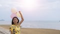 Happy young girl wear yellow shirt and hold balloon at beach Royalty Free Stock Photo