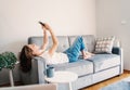 Happy young girl woman in jeans and white t-shirt makes selfie on the couch at home, internet and technology, video chat Royalty Free Stock Photo
