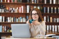 Happy young girl working on laptop computer, sitting in cafe Royalty Free Stock Photo